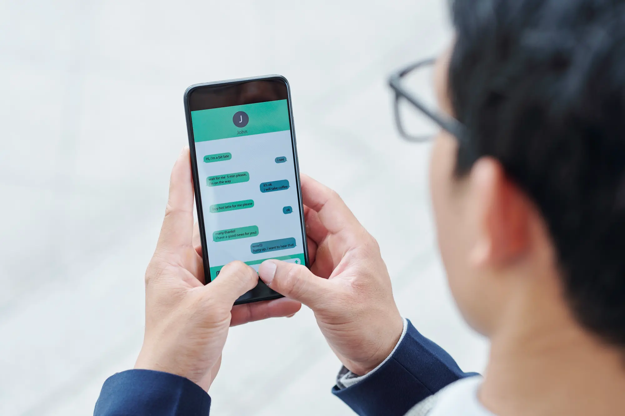 Businessman holding phone, focused on live chat screen for ASuperior Contact Center